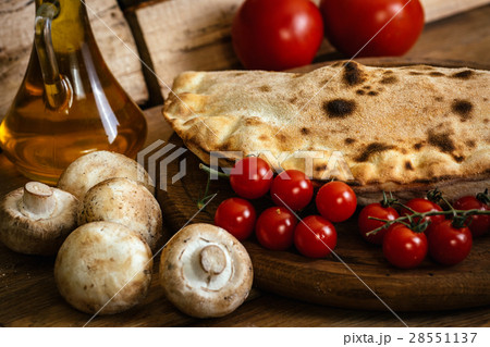 Сalzone pizza on wood table with ingredients 28551137