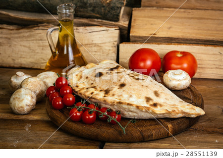 Сalzone pizza on wood table with ingredients Сalzone pizza on wood table with ingredients 28551139