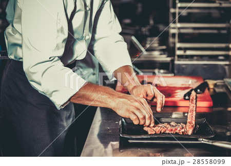 Busy chef at work in the restaurant kitchen Busy chef at work in the restaurant kitchen 28558099