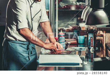 Busy chef at work in the restaurant kitchen Busy chef at work in the restaurant kitchen 28558140