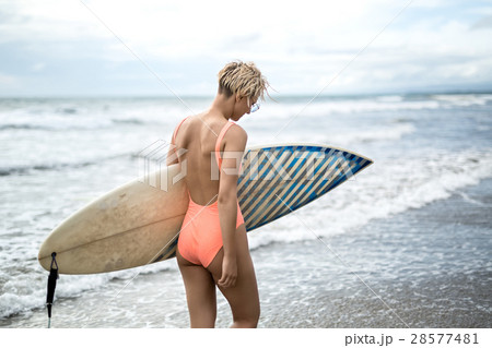 Woman with surfboard on beach 28577481