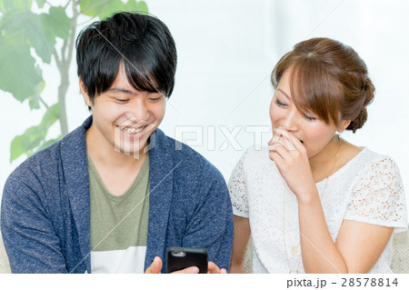 男女でスマートフォンを見る（正面） 28578814