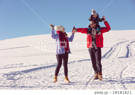 Attractive family having fun in a winter park on 28581821