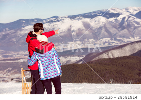 Rear view of a loving couple in fur hood jackets Rear view of a loving couple in fur hood jackets 28581914