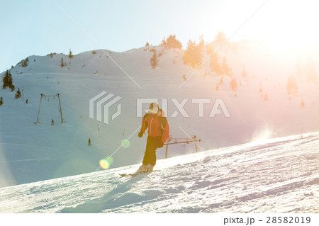 Skier skiing downhill in high mountains against 28582019