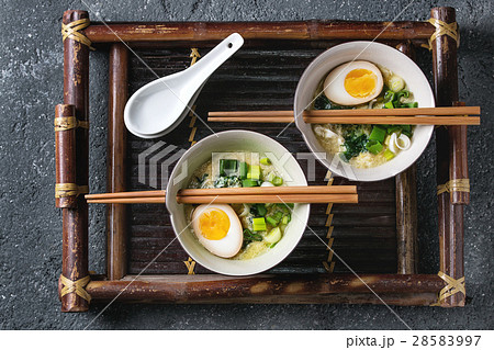 Asian soup with eggs, onion and spinach 28583997