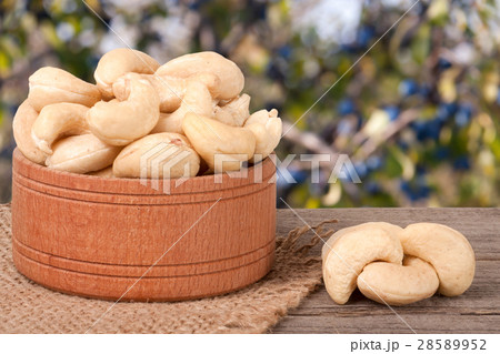 cashew nuts in a wooden bowl on the board with cashew nuts in a wooden bowl on the board with 28589952