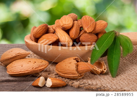 heap of peeled almonds with leaf in a wooden spoon 28589955
