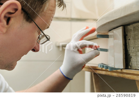 Worker is propping tile. 28590819