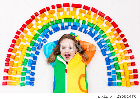 Child playing with rainbow plastic blocks toy Child playing with rainbow plastic blocks toy 28591480