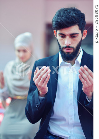 Muslim man and woman praying in mosque 28598071