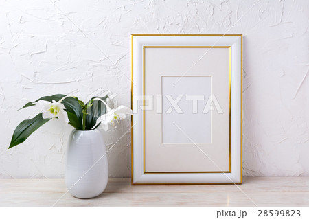 Gold decorated frame mockup with tender white lily 28599823