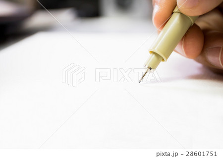 Hand holding pigma pen on blurry focus 28601751
