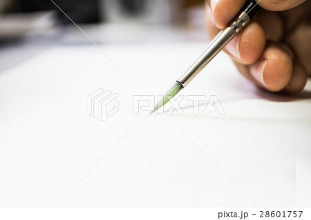 Hand holding paintbrush on blurry focus 28601757