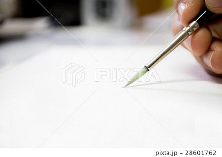 Hand holding paintbrush on blurry focus Hand holding paintbrush on blurry focus 28601762