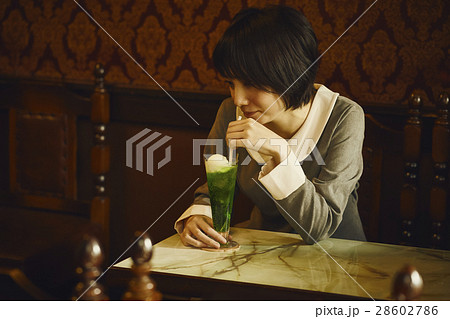クリームソーダを飲む女性の写真素材