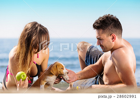 Happy just married couple lay on the beach eating 28602991