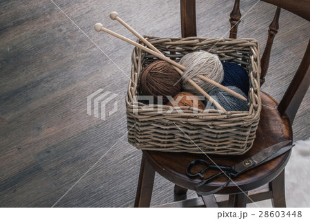 scissors and yarn inside old basket wooden chair 28603448