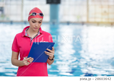 Fit female swimming trainer with tablet at the Fit female swimming trainer with tablet at the 28603642