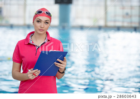 Fit female swimming trainer with tablet at the Fit female swimming trainer with tablet at the 28603643