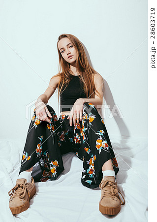 Fashion girl sitting on floor against white wall 28603719