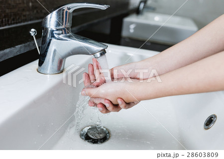 Washing of hands under the crane with water 28603809