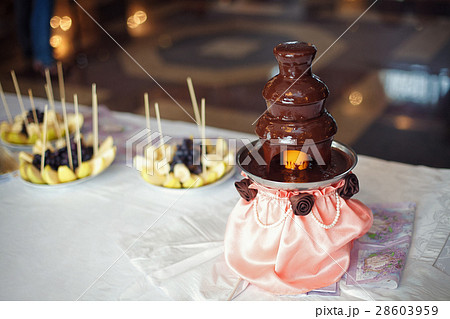 Chocolate fondue fountain with prepared fruits 28603959