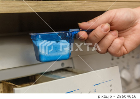 Young woman launching washing machine Young woman launching washing machine 28604616