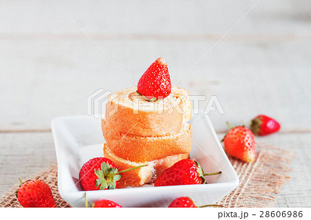 Roll cake on the table. 28606986