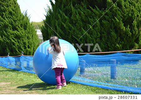女の子 春 公園 バランスボール ボール遊びの写真素材