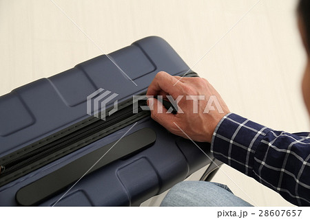 スーツケースを開ける男性手元 28607657