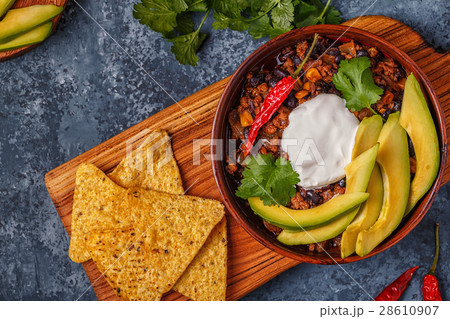 Chili con carne in bowl with avocado, sour cream. 28610907