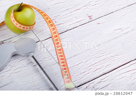 The centimeter stands near a green apple 28612047