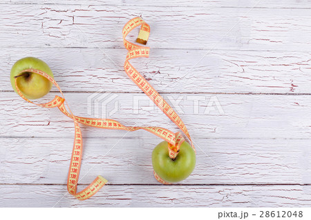 The centimeter stands near  green apples 28612048