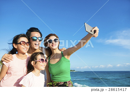 happy family taking a selfie at the beach 28615417