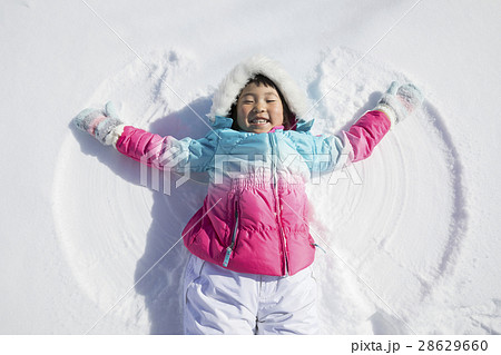雪で天使の羽を作る子供 雪遊びの写真素材