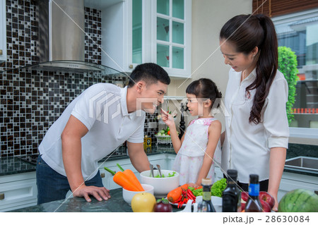 Happy family preparing vegetables together 28630084