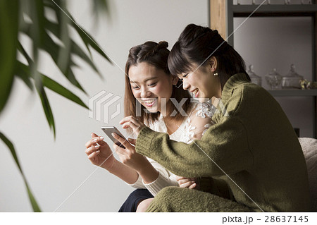 部屋でスマホを見ている女性 28637145