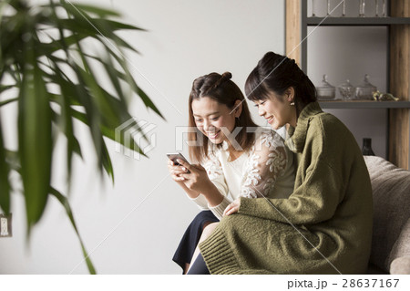 部屋でスマホを見ている女性 28637167
