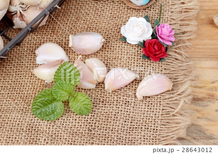 Raw garlic has health benefits on wood background. 28643012