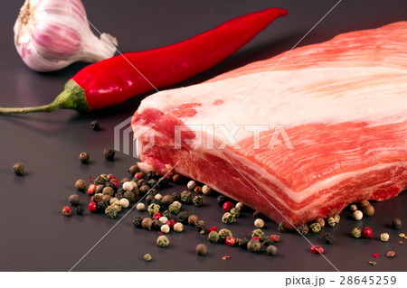 piece of pork on a dark background with peppercorn 28645259
