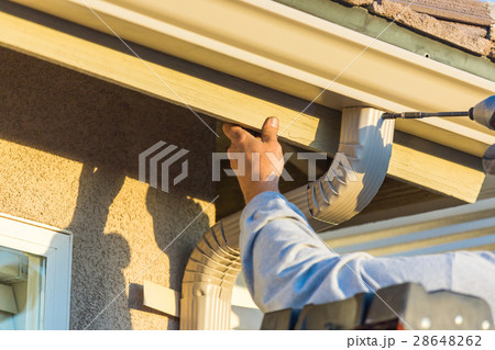 Worker Attaches Aluminum Rain Gutter Down Spout  28648262