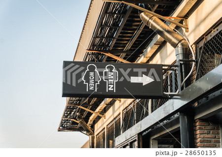 Toilet sign by white spray paint on building 28650135