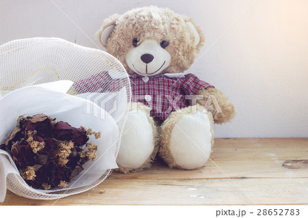Teddy bear with a bouquet of flowers on the wood 28652783