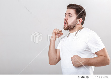 young handsome man with beard in t-shirt listening 28655980