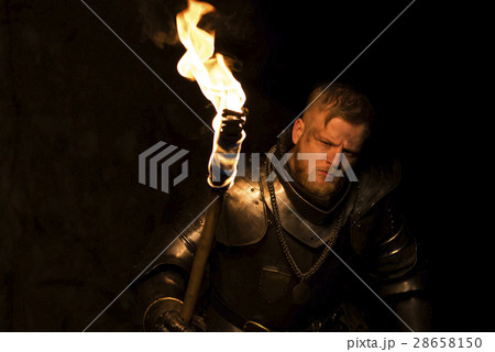 Knight with a torch at night on a wall background Knight with a torch at night on a wall background 28658150