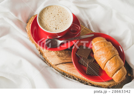 Cappuccino, Chocolate and Croissant on a Bed. Cappuccino, Chocolate and Croissant on a Bed. 28663342