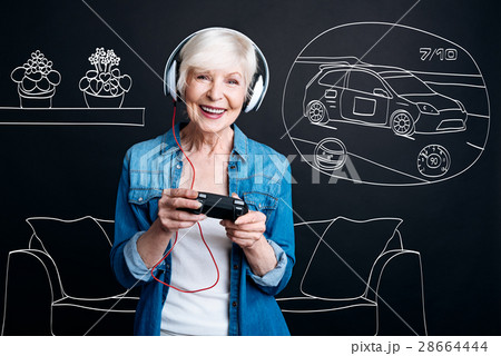 Joyful elderly woman playing video games 28664444