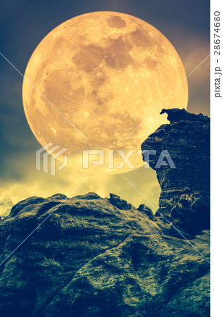 Boulder against sky with clouds and full moon 28674680