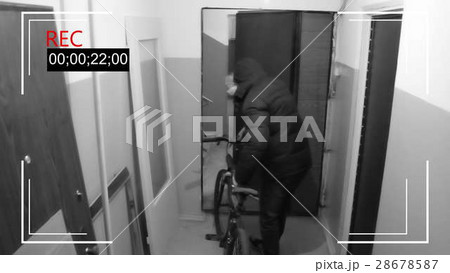 the young man in mask breaks the door and  28678587